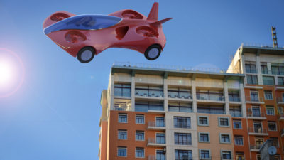 Röd bil som flyger över ett hus.