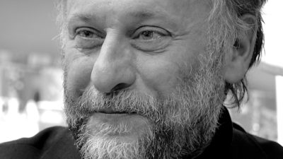 En svartvitMichael Nyqvist ler svagt.