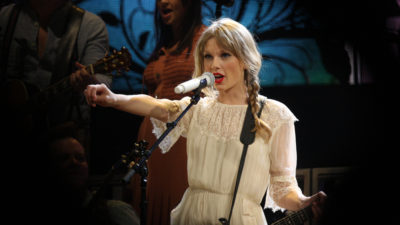 Taylor Swift står på scenen och sjunger.