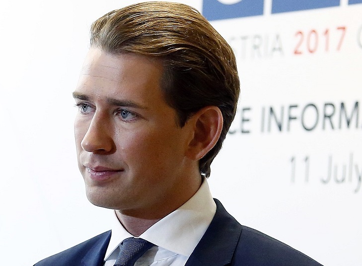 Sebastian Kurz. Han har blont hår som ligger bakåt och blåa ögon. Han ser ung ut. Han har kostym på sig.