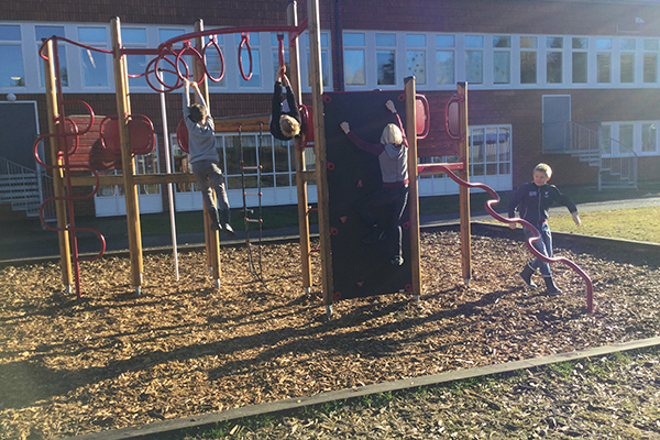 Foto på Pitholmsskolans klätterställning med lekande barn.