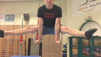 Victor gör en split medan han hänger i ringar.