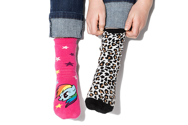 Bild på en persons strumpor som har olika färger och mönster.