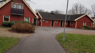 Röda hus runt en grusplan.