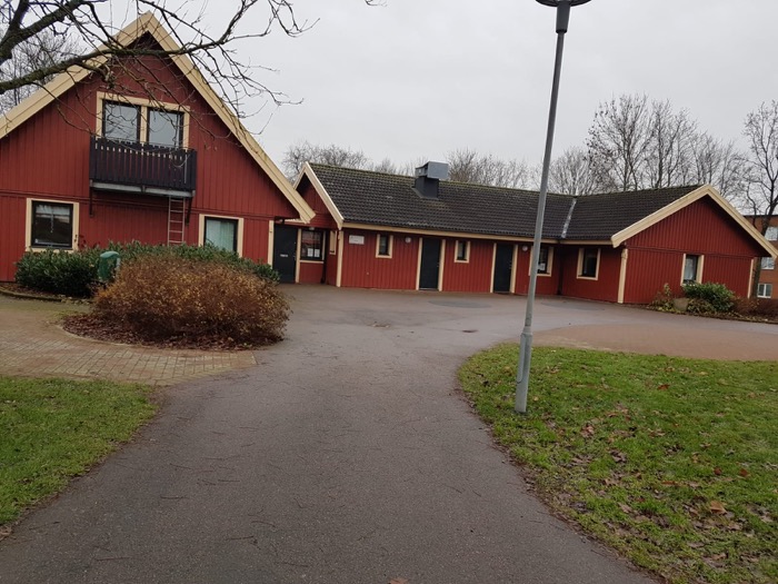 Röda hus runt en grusplan.