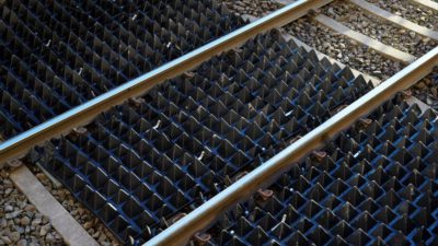 Spetsiga pyramidmattor över ett tågräls