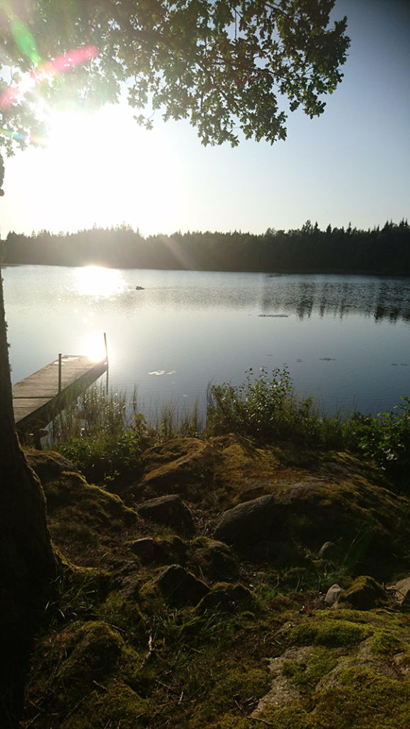 Foto på en solnedgång i ett spegelblankt vattendrag.