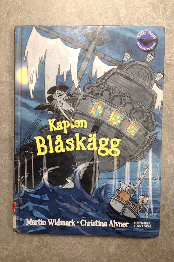 Foto på boken Kapten Blåskägg. Det är ett stort skepp i en storm på framsidan.