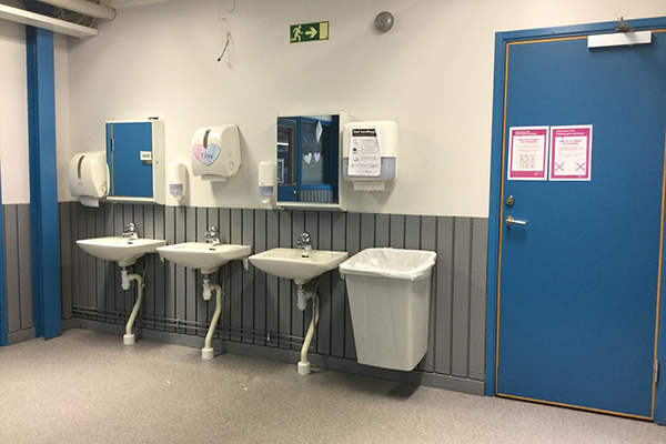 Foto från ingången till skolans matsal. Lappar har satts upp på dörren och väggen.