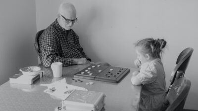 En äldre man och en flicka spelar spel