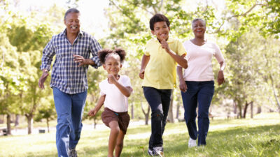 Två barn och två vuxna som springer