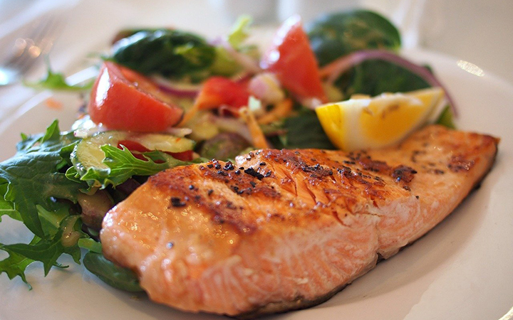 Foto på en tallrik med stekt lax och grönsaker