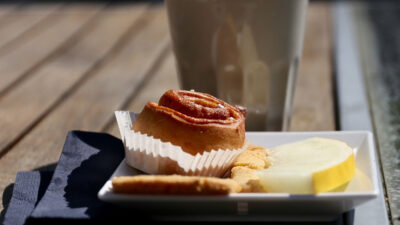 Kanelbulle, melon och en kaffekopp på en brygga.
