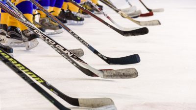 Hockeyspelare står uppradade på isen.