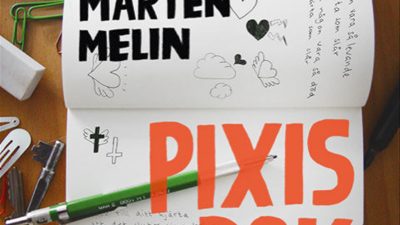 Omslaget till Pixis bok. Foto på en anteckningsbok samt en penna.