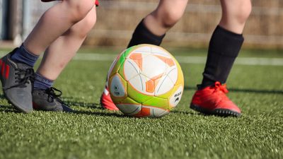Barn som sparkar på en fotboll.
